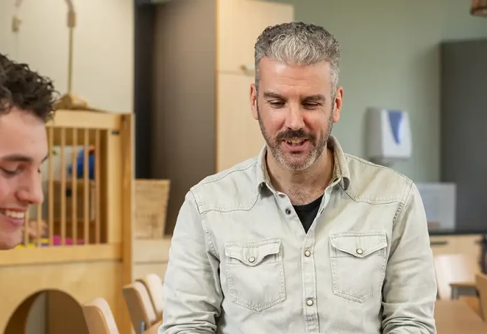 Docent aan tafel met drie studenten