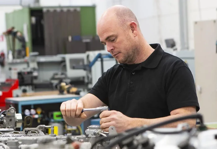 automonteur werkt met dopsleutel aan een werkbank